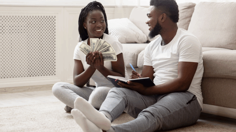 Couple sitting down in living room having a conversation with money in hand.