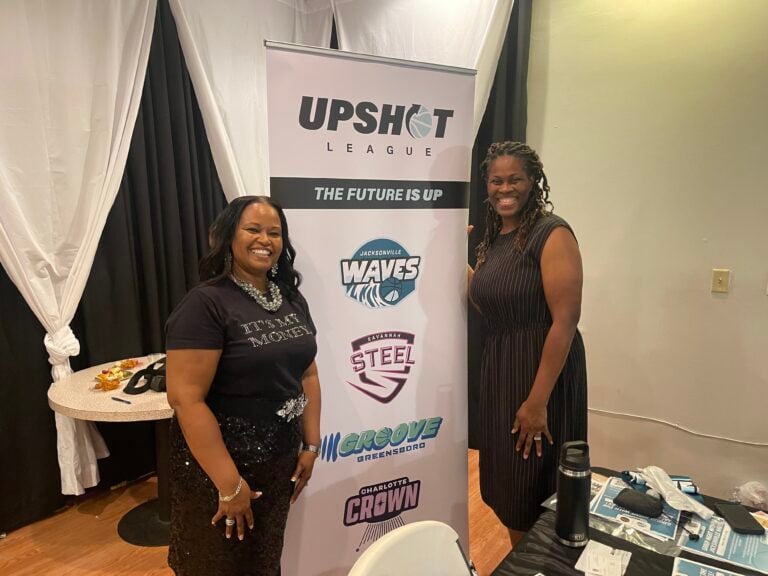 patrina and woman posing on either side of upshot banner